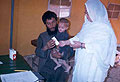 the clinic's nurse is explaining treatment to Jamrod whose one-year old son has malaria. Jamrod's wife, the boy's mother, had to stay in Afghanistan because she had suffered disabling injuries as a result of the war